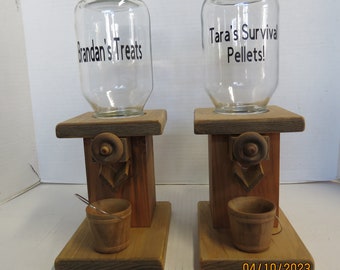 May include: Two wooden candy dispensers with glass jars. The jar on the left says "Brandan's Treats" and the jar on the right says "Tara's Survival Pellets!"