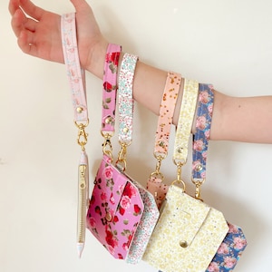 Peut inclure: Six portefeuilles à poignet colorés avec des motifs floraux et des accessoires dorés. Chaque portefeuille a une poche zippée et une dragonne.