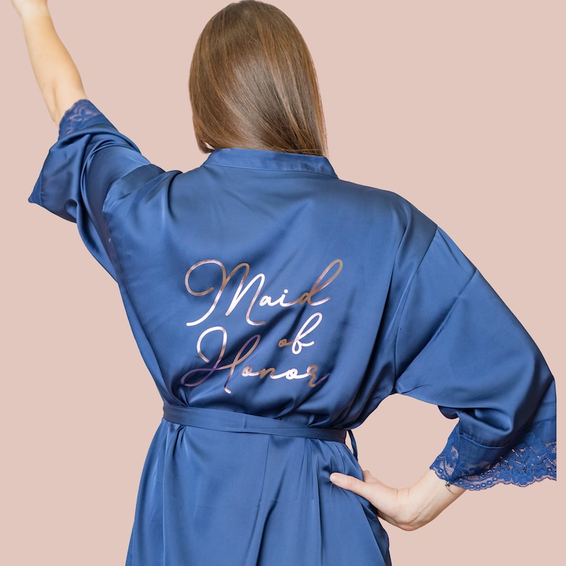 May include: A blue satin robe with a rose gold inscription that reads "Maid of Honor".