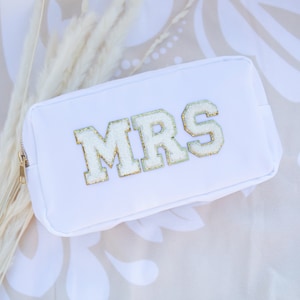 May include: White zippered pouch with the word "MRS" in gold glitter letters.