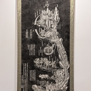 May include: A black and white scroll with intricate illustrations and text in Japanese. The scroll depicts a detailed landscape with mountains, trees, and figures. The text on the scroll is in a traditional Japanese script.
