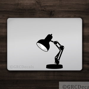May include: Black silhouette of a desk lamp with a flexible arm on a white background. The lamp is in the shape of a classic Pixar lamp. The text "©GRCDecals" is at the bottom of the image.