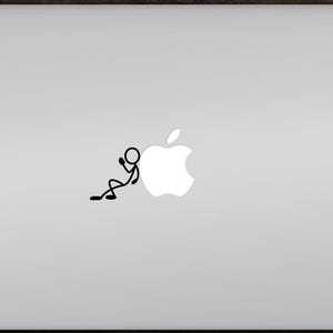 Op de afbeelding: Een zilveren laptop met een zwarte stokfiguursticker die tegen het witte Apple-logo leunt. De laptop staat op een donkerhouten oppervlak. De stokfiguur bevindt zich in een ontspannen houding.