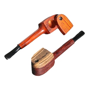 May include: Two wooden smoking pipes. One pipe is red with a black mouthpiece and a small compartment on the side. The other pipe is brown and red with a black mouthpiece.