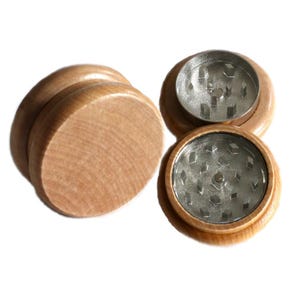 May include: Three wooden grinder pieces with a metal grinding mechanism. The grinder is made of light brown wood and has a silver metal grinding mechanism.