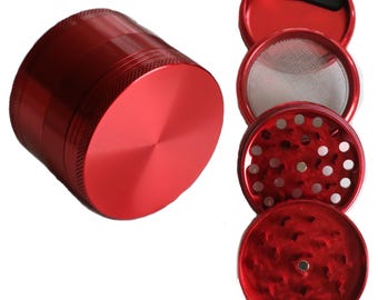 Puede incluir: Un molinillo de metal rojo con cuatro partes: una tapa, una malla, una cámara de molienda y una cámara de recolección. El molinillo está hecho de metal duradero y tiene un acabado liso.
