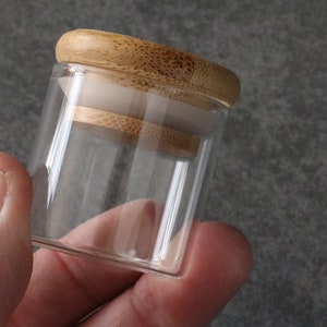 May include: A clear glass jar with a bamboo lid. The lid has a rubber seal to keep the contents fresh.