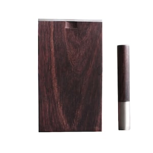 May include: A dark brown wooden box with a silver metal top and a matching dark brown wooden cylinder with a silver metal top.