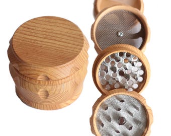 May include: A wooden herb grinder with four separate compartments. The top compartment is a wooden lid, the second compartment has a coarse metal screen, the third compartment has a fine metal screen, and the bottom compartment is a collection tray.