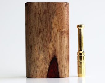 May include: A wooden dugout with a rectangular shape and a contrasting dark red wood grain pattern at the base. A gold-colored metal one-hitter pipe is positioned next to the dugout.