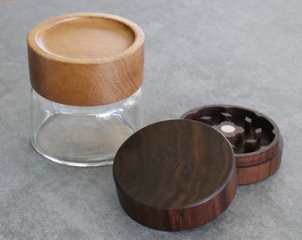 May include: Two wooden containers, one with a clear glass bottom and a wooden lid, the other with a wooden lid and a grinder inside.