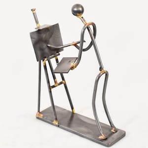 May include: A metal sculpture of an artist at work. The figure is made of dark metal rods, with a sphere for the head. The artist is depicted with an easel and a palette, creating a unique art-themed decorative piece.