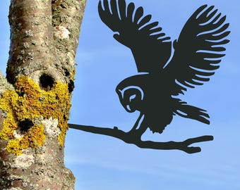 May include: Black silhouette of an owl with wings spread, perched on a branch. The owl is facing left and has a detailed design.