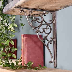 May include: A decorative cast iron shelf bracket with a scroll design. The bracket is painted in a dark grey colour and is attached to a wooden shelf.