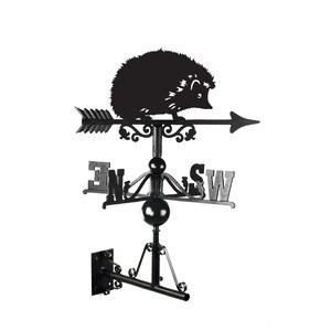 May include: Black metal hedgehog weather vane with a compass rose and the directions N, E, S, and W. The vane is mounted on a black metal bracket.