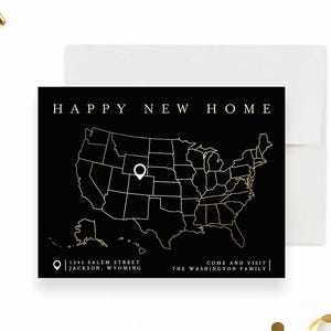 May include: A black and gold new home announcement card featuring a map of the United States. The card has the text "HAPPY NEW HOME" at the top. The address "1245 SALEM STREET JACKSON, WYOMING" is printed at the bottom, along with "COME AND VISIT THE WASHINGTON FAMILY."
