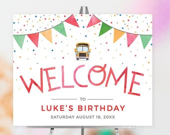 May include: Welcome to Luke's Birthday sign with a yellow school bus and colorful bunting. The sign is on a white background with confetti.