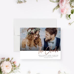 May include: Wedding announcement card featuring a photograph of a couple against a blurred backdrop. The text reads "The Clarks, Belinda and Colin, Married in a Private Ceremony on July 28th, 2024."