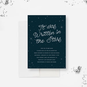 May include: A dark blue baby shower invitation with silver glitter stars forming the words "It was written in the stars". The invitation includes details for an adoption baby shower in honor of Ann Davidson on January 28th, 20XX from 1-3 PM at 1238 Forest Lake Los Angeles, CA. RSVP by January 12th, 20XX. Registered at Moms and Bubs.