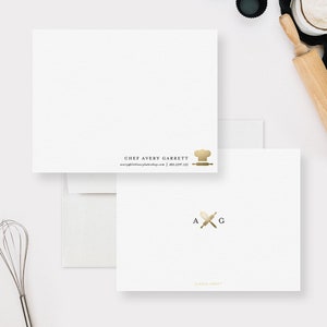 May include: Gold foil business card with a chef hat and rolling pin design. The text reads "Chef Avery Garrett" and includes a website and phone number. The back of the card has a gold foil design of a whisk and rolling pin with the initials "A G" and the text "Claudia Owen".
