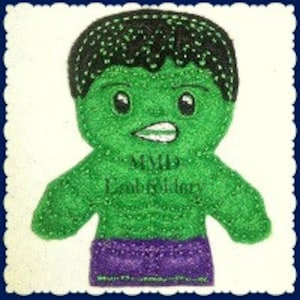 Può includere: Burattino per dita di feltro verde di Hulk, un supereroe con corpo verde, capelli neri e una cintura viola. Il burattino ha un grande sorriso e un'espressione determinata.