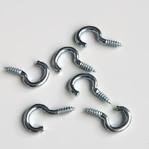 May include: Six silver screw-in hooks with a rounded loop on a white background.