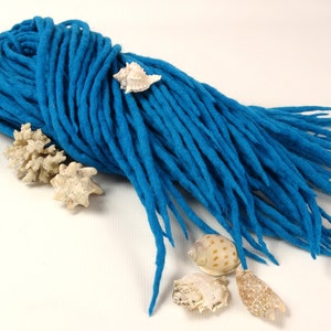 Könnte beinhalten: Ein Bündel hellblauer Woll-Dreadlock-Verlängerungen. Die Wolle ist weich und flauschig, und die Verlängerungen sind lang und fließend. Die Verlängerungen sind perfekt, um Ihrem Haar Länge und Volumen zu verleihen.