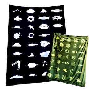 May include: Two tapestries with geometric designs. One tapestry is black with white geometric shapes, including circles, triangles, and squares. The other tapestry is green with yellow geometric shapes, including circles, spirals, and stars.