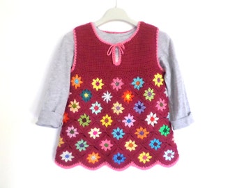 Pull sans manche fille au crochet, fleurs multicolores sur fon rouge framboise. Taille 6/8 ans