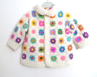 Crochet wool cardigan with multicolored flowers on a white background. SIZE 18 months / 3 years