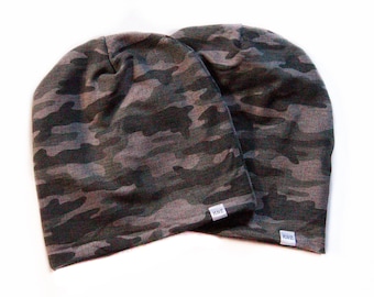 May include: Two gray and green camouflage beanie hats with a white label that says "KUZ"