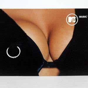 May include: A black bra with a silver ring on the strap. The bra is on a woman's chest. The image has the MTV logo and the text "MUSIC TEL" in the top right corner.