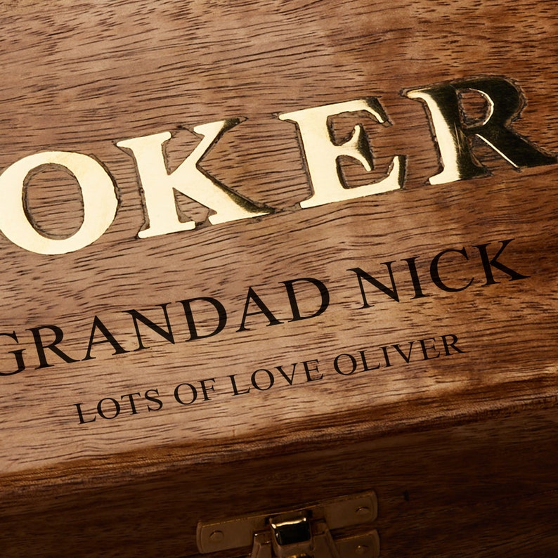 May include: A wooden box with a gold inscription that reads "Joker Grandad Nick Lots of Love Oliver".
