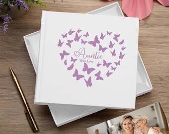 May include: White photo album with a purple butterfly heart design. The album has the text "Auntie with Love" on the front.