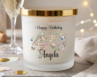 Könnte beinhalten: Eine Kerze aus mattiertem Glas mit goldenem Rand, mit dem Text "Happy Birthday 40 Angela". Die Zahlen sind mit Blumen und Schmetterlingen verziert. Ein Sektglas und Konfetti sind im Hintergrund.