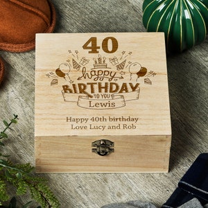 May include: A wooden box with a hinged lid and a metal clasp. The box is engraved with the text "40 happy birthday to you Lewis" and "Happy 40th birthday Love Lucy and Rob".
