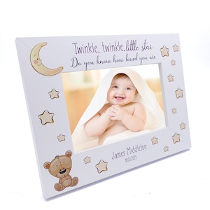May include: White wooden photo frame with a moon and stars design. The frame has a cutout for a photo and includes the text "Twinkle, twinkle, little star Do you know how loved you are."  The frame also includes a teddy bear and the text "James Middleton 16.03.2021".