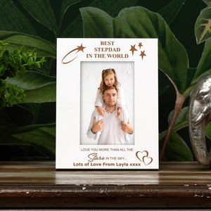 May include: White photo frame with a brown inscription that reads "Best Stepdad in the World". The frame has a photo of a man and a girl. The inscription also reads "Love you more than all the stars in the sky... Lots of Love From Layla xxxx".