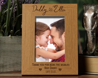 May include: A wooden photo frame with the words "Daddy & Ellie" engraved at the top. The frame holds a photo of a father and child. The bottom of the frame reads "Thank you for being the world's best daddy, love Ellie."