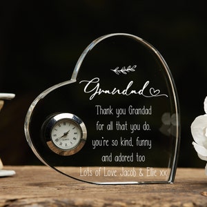 May include: A heart-shaped crystal clock with a small clock face and the inscription "Grandad Thank you Grandad for all that you do. you're so kind, funny and adored too Lots of Love Jacob & Ellie xx"