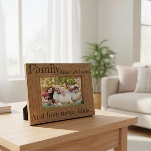 A wooden picture frame with a family photo inside, placed on a wooden table in a living room.