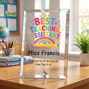 May include: A rectangular glass plaque with beveled edges featuring the colorful text BEST TEACHING ASSISTANT, a rainbow, and a yellow pencil graphic. Below, the text reads Miss Francis, Thank you for all that you did, From Toby Yr 6.