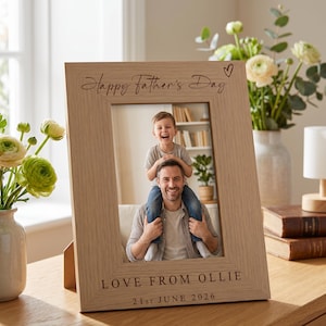 May include: A light-colored wooden picture frame with the text "Happy Father's Day" and a heart symbol. The frame holds a photo of a man with a child on his shoulders. The text "LOVE FROM OLLIE" and the date "21st JUNE 2026" are also engraved.