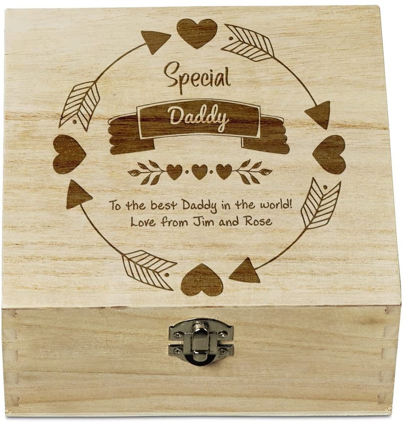 以下が含まれることがあります： ヒンジ付きの蓋とラッチが付いた木製の箱。蓋には「Special Daddy」と「To the best Daddy in the world! Love from Jim and Rose」という文字が刻まれています。彫刻は矢印とハートの円に囲まれています。