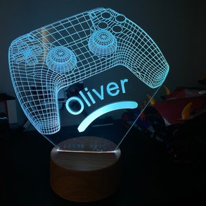 May include: A blue and white 3D printed gamer controller night light with the name "Oliver" on the base.