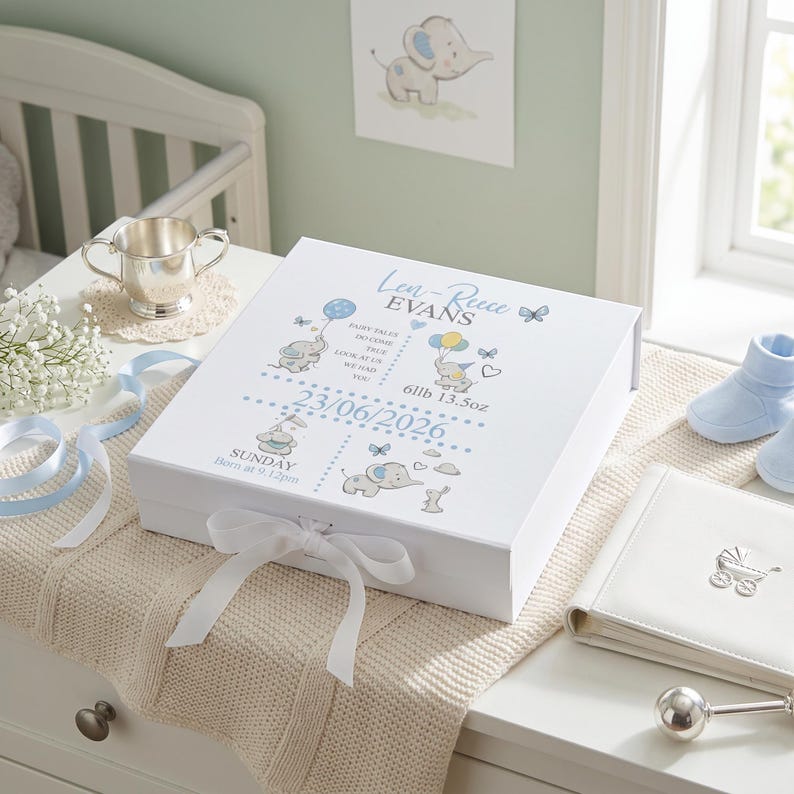 A white gift box with illustrations and text, placed on a beige blanket on a dresser.