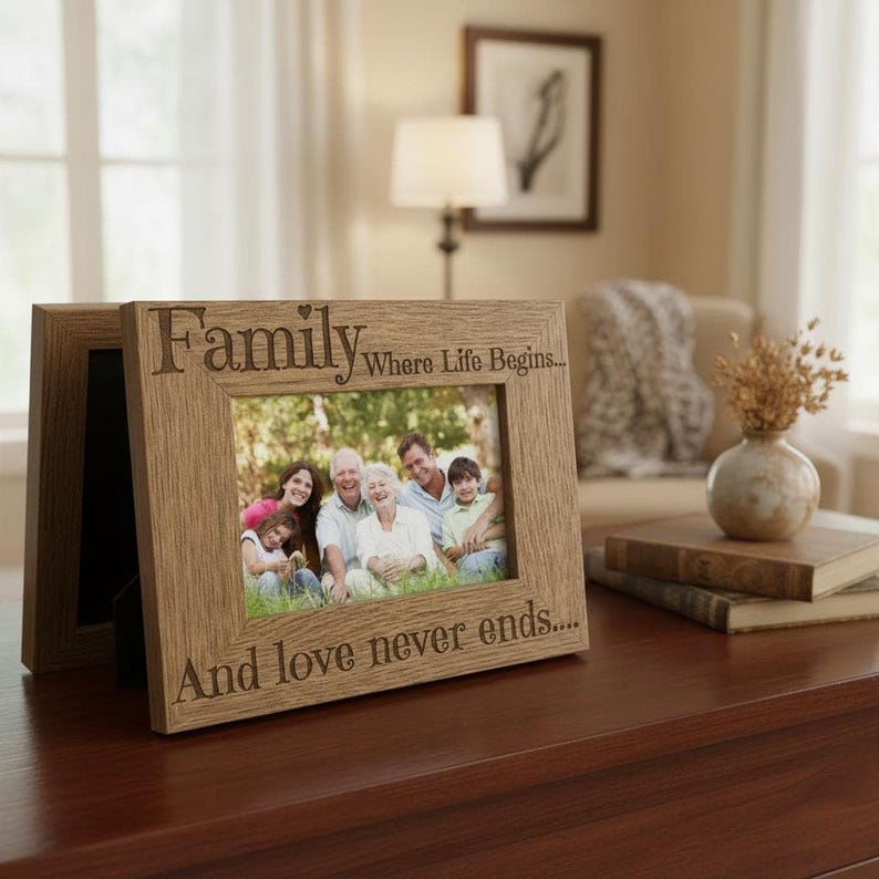 A wooden picture frame with a family photo inside, placed on a wooden surface. The frame has a message that reads "Family Where Life Begins... And love never ends..."