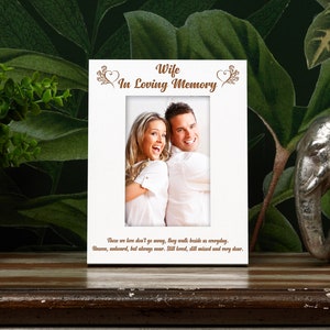 May include: White picture frame with a photo of a couple and the text "Wife In Loving Memory" in brown lettering. The text below the photo reads "Those we love don't go away, they walk beside us everyday. Unseen, unheard, but always near. Still loved, still missed and very dear."