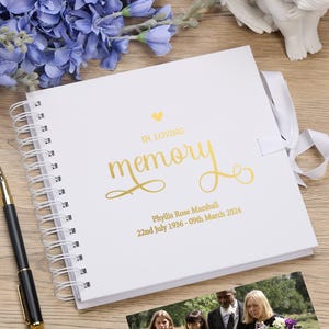 May include: White spiral bound memory book with a gold foil heart and the words "In Loving Memory" in gold foil lettering. The book also includes the name "Phyllis Rose Marshall" and the dates "22nd July 1936 - 09th March 2024" in gold foil lettering.