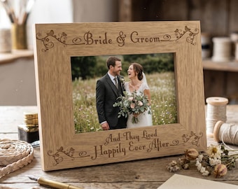 May include: A wooden picture frame with the words "Bride & Groom" and "And They Lived Happily Ever After" engraved on it. The frame holds a wedding photo of a couple. The frame is made of light-colored wood.